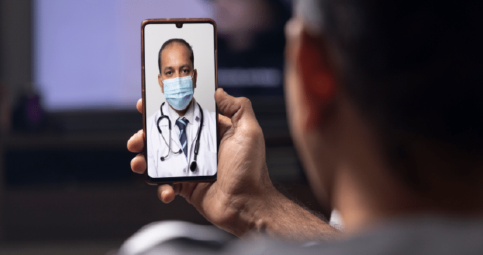 “Man using online doctor consultation for men on phone at home”